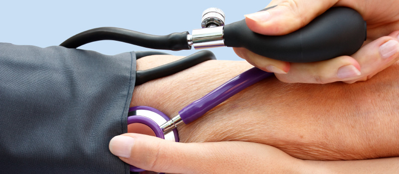 close-up of nurses hands and a blood pressure cuff on a patients arm