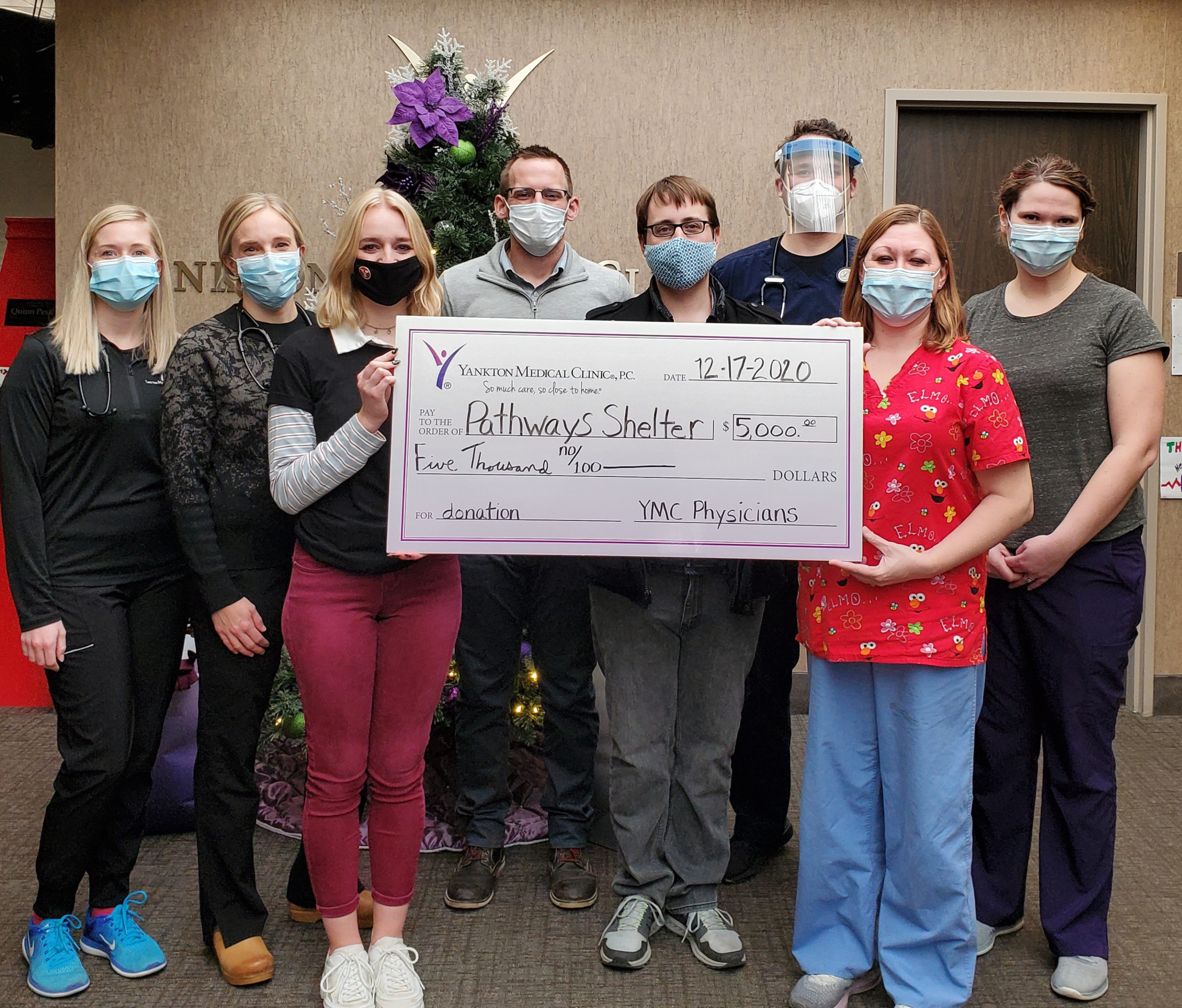 Yankton Medical Clinic physicians and Pathways Shelter for the Homeless accept a check for a donation.